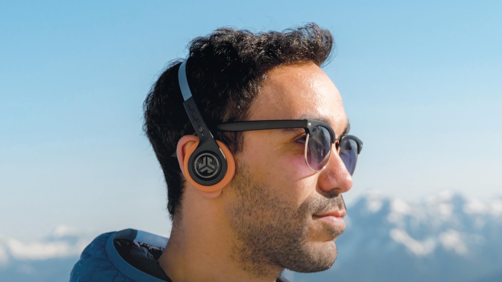 man with sunglasses wearing JLab rewind headphones